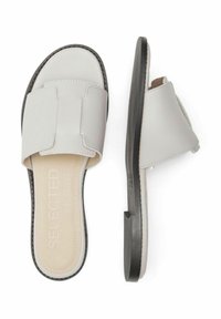 Grijze slipper-sandalen met een brede bovenband en minimalistisch ontwerp. Getextureerde zool met zwarte accenten en verhoogde branding op de binnenzool.