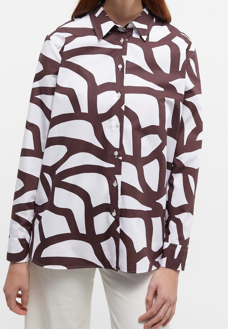 Camicia bianca con bottone e un motivo astratto marrone, colletto classico, maniche lunghe e texture di tessuto morbida.