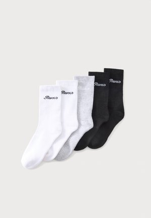 Cinq paires de chaussettes basses en blanc, gris et noir, chacune avec un petit logo de marque brodé près du bord supérieur.