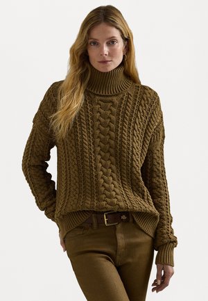 Brauner, kabelgestrickter Pullover mit hohem Rippkragen und texturiertem Muster, kombiniert mit braunen, taillierten Hosen und einem braunen Gürtel.