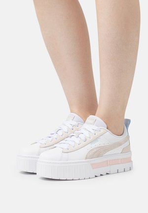 White platform sneakers with grey suede accents and light pink details. Textured sole, rounded toe, and contrasting light blue heel tab.