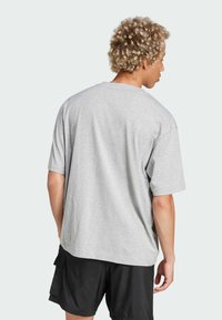 Grå bomull t-shirt med kort ärm, rund hals och avslappnad passform. Har en slät, mjuk textur och minimala sömnadsdetaljer.