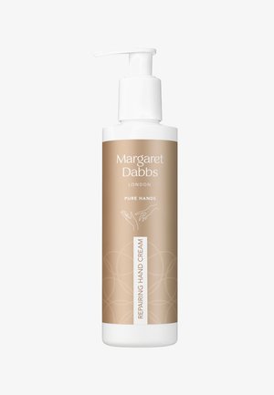 Flacon de crème réparatrice pour les mains avec pompe, étiqueté Margaret Dabbs London Pure Hands, emballage beige et blanc, illustration minimaliste de main sur l'étiquette.