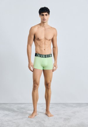 Zelene bombažne bokserice z črnim pasom z logotipom Calvin Klein, oblikovane za prileganje, gladka tekstura in klasična oblika.