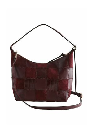 Dark red patchwork shoulder bag with short and long straps and a top zipper closure against white background.