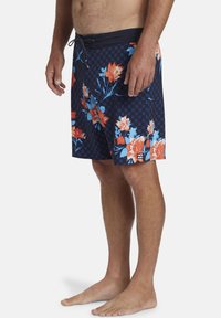 Costume da bagno navy con motivo floreale in tonalità di rosso, arancio e blu; texture a scacchi; cintura elastica con cordino; lunghezza fino al ginocchio.