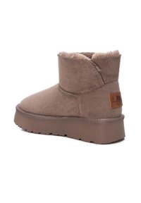 Botín marrón de tobillo hecho de tela suave, con forro de felpa, cuello acolchado y suela de goma gruesa con detalles texturizados.