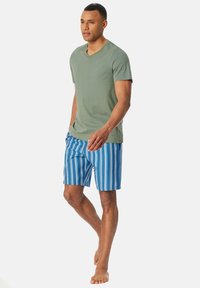 Zielona koszulka typu v-neck zestawiona z niebieskimi i białymi w pasy szortami kąpielowymi. Szorty mają elastyczny pas i boczne kieszenie.