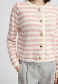 Rozā un baltu svītrainu kardigāns ar apaļu kakla izgriezumu, ar četriem zeltainiem pogām un teksturētu adījumu. Ikdienišķs piegriezums.