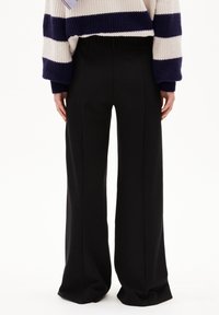 Black wide-leg trousers with a smooth texture and tailored design, featuring a high waist and clean lines. Back view shown.