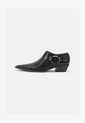 Botine negre din piele, cu vârful ascuțit, având o curea din piele în față și detalii cu cataramă argintie, precum și un toc mic, pătrat.