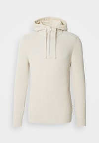 Sweatshirt com capuz de cor creme com um design de malha texturizada, fecho de meia-zíper e punhos e bainha canelados. Apresenta um forro interior leve.