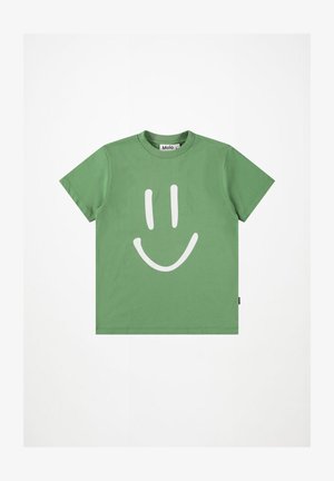 Zelené bavlnené tričko s veľkým bielym grafickým obrázkom usmievavého tváre na prednej strane. Krátke rukávy a okrúhly výstrih. Štítok viditeľný na boku.