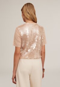 Blush kortærmet top med en sequined ryg med hexagonale mønstre; blød tekstur; løst fit med et cropped design.