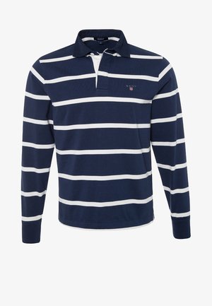 Maglia da rugby a maniche lunghe blu navy con strisce orizzontali bianche, colletto, patta con tre bottoni e piccolo logo GANT sul petto a sinistra.