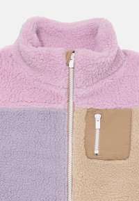 Fleecejakke med høy krage, med seksjoner i rosa, lavendel og beige. Glidelås foran og brystlomme i et beige stoff.