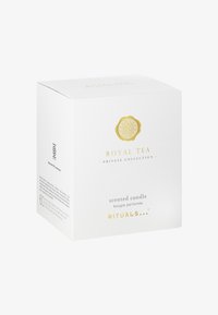 Hvit eske for et duftlys med gullakenter, med preget logo, tekst som indikerer "Royal Tea," og minimalistisk design.
