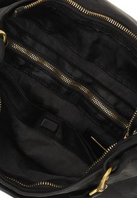 Interno di una borsa nera in pelle con molteplici tasche, cerniere dorate e foderatura testurizzata. Design strutturato adatto per l'organizzazione.