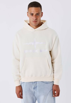 Crèmekleurige hoodie van zacht materiaal, met een voorkruiszak, ribgebreide manchetten en een witte logoprint op de borst.