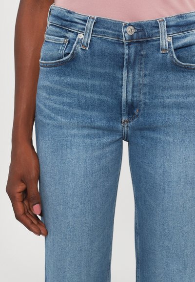 Blue denim jeans with a high waist, featuring a button closure, five pockets, and subtle fading details along the thighs.