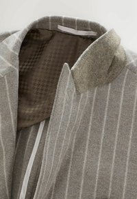 Gray wool coat with pale stripes; features a textured collar and brown patterned lining. Designed with a front opening and interior details.