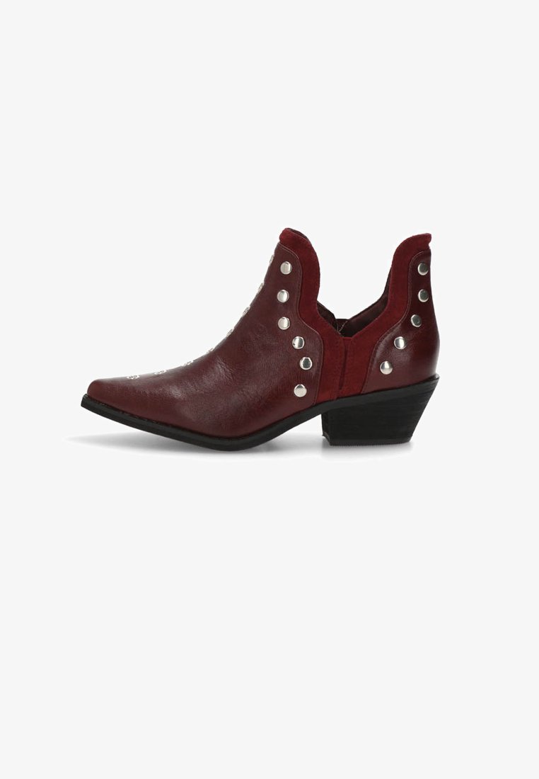Bota de tobillo burdeos con punta afilada, materiales de tela y cuero sintético, detalles de tachuelas plateadas y un tacón bajo y angulado.