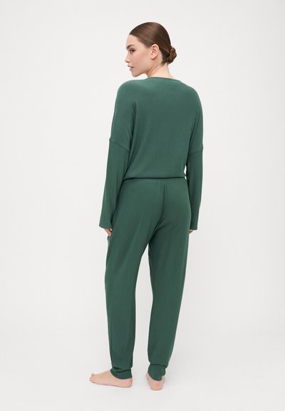 Green loungewear set featuring a loose-fitting top with wide sleeves and tapered pants with an elastic waistband, made from soft, breathable fabric.