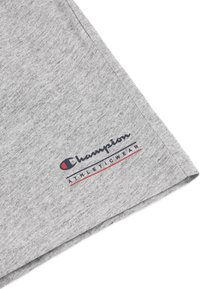 T-shirt in cotone grigio con maniche arrotolate, con un logo "Champion Athleticwear" rosso e blu sul davanti. Texture morbida, design casual.