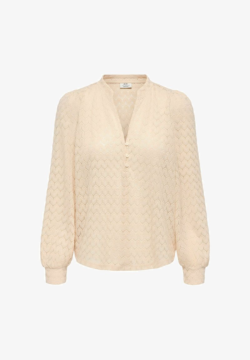 Blouse beige à manches longues avec motif hexagonal texturé, manches légèrement bouffantes, encolure en V et trois petits boutons à l'avant.