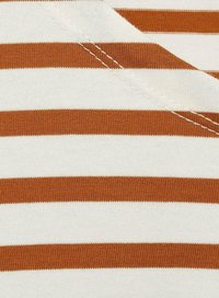 Tissu en coton avec des rayures horizontales en crème et rouille, présentant des coutures visibles et une texture douce.