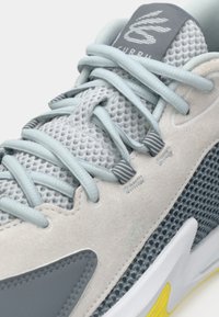 Grauer und hellblauer Sneaker mit einem Obermaterial aus Mesh, strukturierten Wildlederpaneelen und kontrastierender Gummisohle, ausgestattet mit flachen Schnürsenkeln und Logo auf der Zunge.
