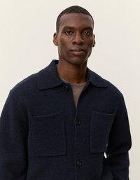 Navy vilnas maisījuma jaka ar apkakli, ar pogām aizdara priekšpusi un divām krūšu kabatām. Strukturēta auduma ar brīvu piegriezumu.