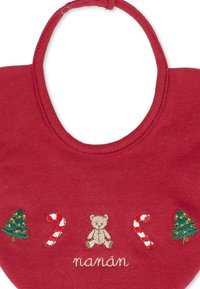 Un bavoir en coton rouge avec des designs brodés d'un ours en peluche, de deux cannes en sucre et de deux sapins de Noël, avec le mot "nanán" en blanc.