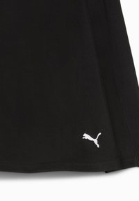 Jupe de sport noire en tissu extensible, avec une texture lisse et un logo Puma blanc en bas à droite.
