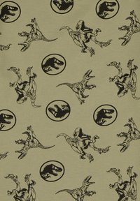 Tela verde claro con gráficos de dinosaurios negros, incluyendo T. rex y otras especies, con íconos circulares de cabezas de dinosaurios, en un patrón repetido.