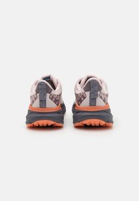 Scarpe da ginnastica grigie e rosa con una parte superiore testurizzata, suola arancione e un accento decorativo sul tallone. Design senza lacci con una linguetta per facilitarne l'indossamento.