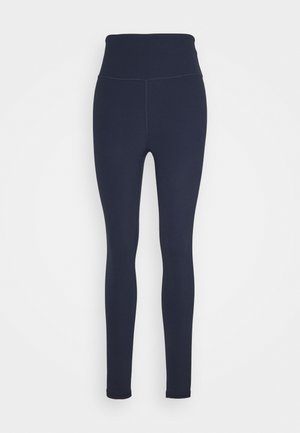 Leggings marine à taille haute, fabriqués à partir d'un tissu lisse et extensible. Ils présentent un design sans couture et une coupe ajustée, sans éléments visibles.