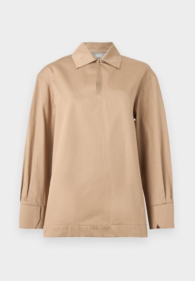 Chemise beige à manches longues avec col pointu, encolure goutte d'eau avec bouton, et larges poignets sur fond uni.