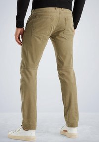 Khaki cotton pants with straight legs, featuring back pockets and a smooth texture, paired with white sneakers.