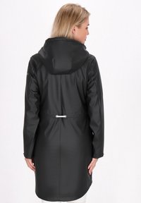 Czarny wodoodporny płaszcz z kapturem, przewężoną talią i długimi rękawami. Gładka faktura bez widocznych wzorów czy detali metalowych.