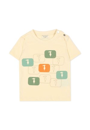 Maglietta color crema per bambino con girocollo, bottoni sulle spalle e blocchi verdi, arancioni e beige con silhouette di uccelli sul davanti.