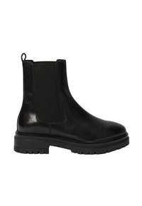 Bottines Chelsea en cuir noir avec panneaux élastiques latéraux, bout arrondi, semelle en caoutchouc épaisse et tirette à l'arrière. Texture lisse et détails minimalistes.