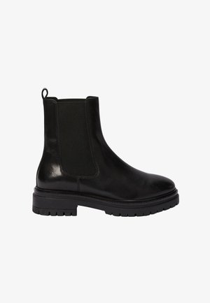 Bottines Chelsea en cuir noir avec panneaux élastiques latéraux, bout arrondi, semelle en caoutchouc épaisse et tirette à l'arrière. Texture lisse et détails minimalistes.