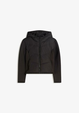 Doudoune noire à capuche, avec fermeture éclair, textures contrastées lisse et matelassée, et coutures inclinées.