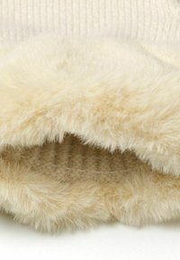 Intérieur doublé de fausse fourrure crème avec une texture douce, contrastant avec une couche extérieure côtelée dans une teinte claire et neutre.