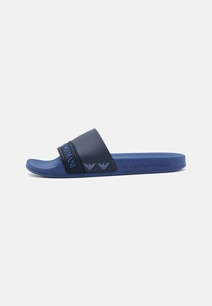 Blaue Slides-Sandale mit einem strukturierten Riemen, der das Emporio Armani-Logo zeigt, und eingeprägtem Markennamen an der Seite der Sohle.