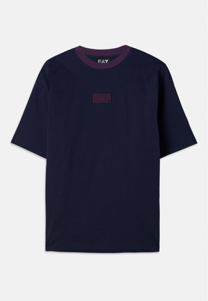 Un tricou bleumarin cu guler rotund ribetat de culoare violet, mâneci scurte și o etichetă rectangulară cu numărul "70" în violet închis.
