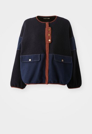 Giacca gonfiabile blu navy e blu scuro con colletto tondo, chiusura con bottoni marroni e due tasche frontali con accessori in oro.