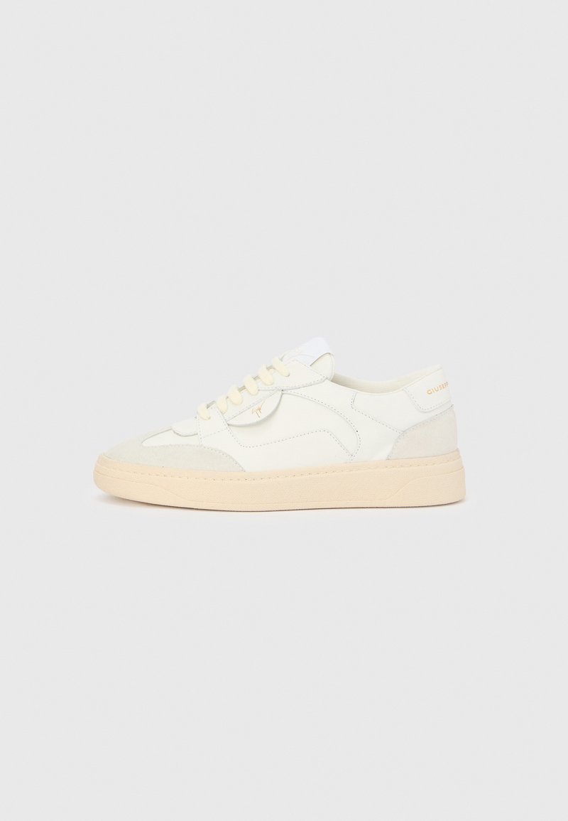 Baskets en cuir blanc à finition lisse, avec des accents en daim et une semelle en caoutchouc beige. Elles présentent un design à lacets et des détails de marque discrets.