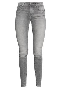 Jeans skinny grises de denim, con un diseño clásico de cinco bolsillos y una textura suave y escalonada. La cinturilla cuenta con un cierre de botón metálico.
